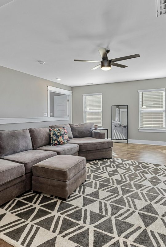 Cozy modern living room with a large sofa, TV, and stylish decor.