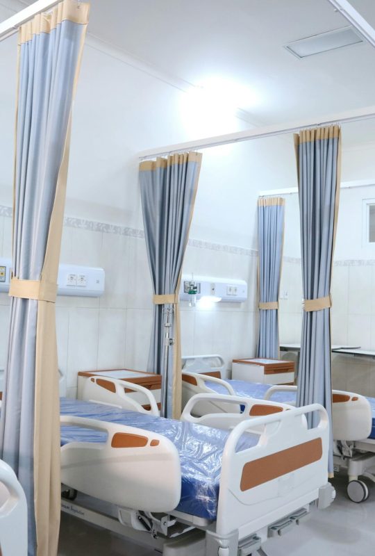 Spacious hospital ward with modern equipment and private patient areas.
